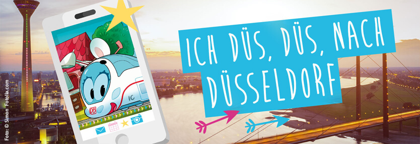 "Ich, Düs, Düs, nach Düsseldorf". Ida lächelt durch ein Handy-Display. Düsseldorf ist im Hintergrund.